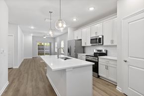 Asheville apartment for rent - A modern kitchen with white cabinets and a large island.