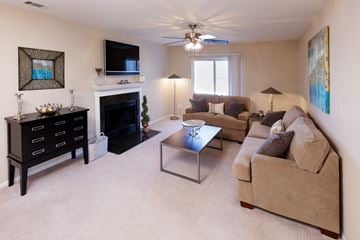 Strongsville apartment for rent - A living room with a fireplace, a couch, a coffee table, and a painting on the wall.