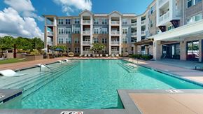 Chapel Hill apartment for rent - A large swimming pool in front of a multi-story apartment building.