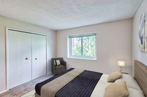 Amherst apartment for rent - A bedroom with a bed, chair, and wardrobe.