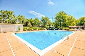 Amherst apartment for rent - A large outdoor swimming pool surrounded by trees and a fence.