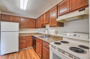 Pittsburgh apartment for rent - A kitchen with white appliances and wooden cabinets.
