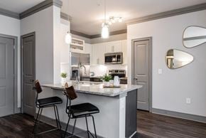 Huntersville apartment for rent - a kitchen with a marble counter top and two stools