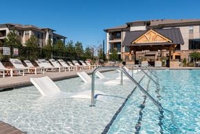 Huntersville apartment for rent - a swimming pool with chairs and a building in the background