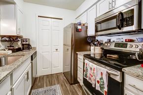 Parma apartment for rent - A kitchen with a black stove top oven and a black microwave above it.