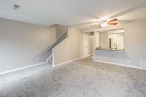 Stow apartment for rent - A spacious room with a staircase and a ceiling fan.