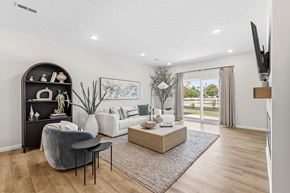 Brook Park apartment for rent - A living room with a grey chair, a black shelf, a white sofa, and a wooden coffee table.