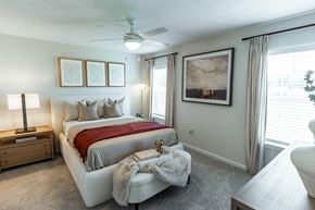 Beavercreek apartment for rent - A bedroom with a large bed and a ceiling fan.