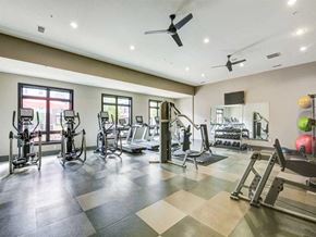 Rocky River apartment for rent - A spacious gym with a variety of equipment and a fan on the ceiling.