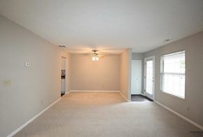 Westlake apartment for rent - A spacious empty room with a carpeted floor and a window on the right side.