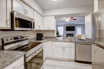 Stow apartment for rent - A kitchen with white cabinets and granite countertops.
