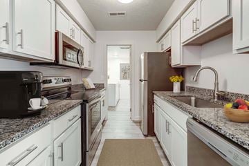 Westlake apartment for rent - A kitchen with white cabinets and a black microwave.