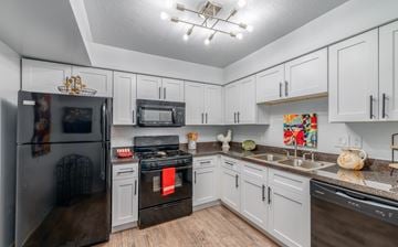 Middleburg Heights apartment for rent - A kitchen with white cabinets and a black stove top oven.