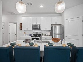 Parma Heights apartment for rent - a kitchen with white cabinets and a table with blue chairs