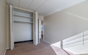 Stow apartment for rent - A room with a white wall and a white closet with shelves.