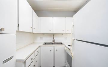 Stow apartment for rent - A kitchen with white cabinets and appliances.