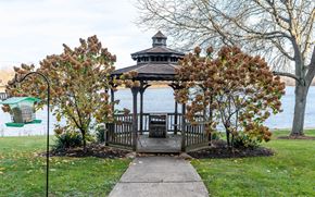 Stow apartment for rent - A gazebo is surrounded by trees and is located by a lake.