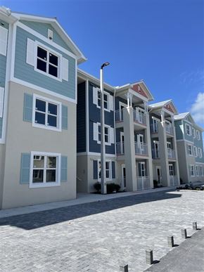 Key West apartment for rent - A row of multi-story buildings with balconies and shutters.