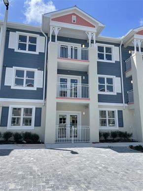 Key West apartment for rent - A multi-story building with a red roof and white railings.