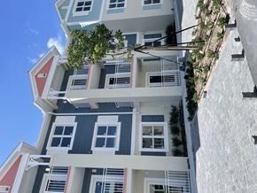 Key West apartment for rent - A building with a red roof and white walls with windows and balconies.
