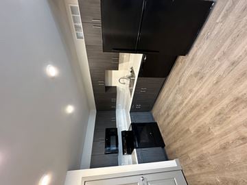 Key West apartment for rent - A kitchen with a black counter top and a white cabinet.