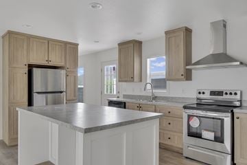 Tucson apartment for rent - A kitchen with a stainless steel refrigerator and oven, and wooden cabinets.