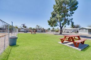 Tucson apartment for rent - A red picnic table sits on a concrete slab in a grassy park.