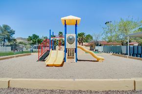 Tucson apartment for rent - A playground with a yellow slide and a red and blue structure.