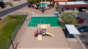 Tucson apartment for rent - A basketball court is surrounded by a green fence and a playground.