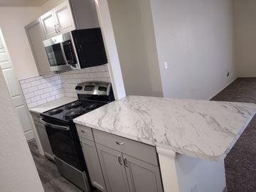 Pueblo apartment for rent - A kitchen with a marble countertop and stainless steel appliances.