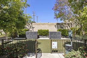 Bakersfield apartment for rent - A sign with a bicycle symbol is attached to a fence in a green space.
