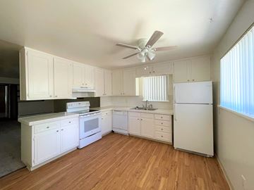 Lakewood apartment for rent - an empty kitchen with white appliances and a ceiling fan