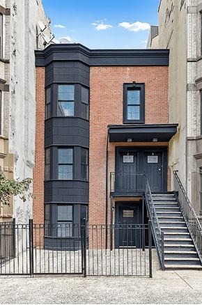 Brooklyn apartment for rent - A black and red building with a black door and stairs leading to it.
