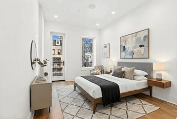 Brooklyn apartment for rent - A bedroom with a large bed and a painting on the wall.