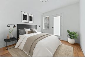 Brooklyn apartment for rent - A bedroom with a large bed and a plant on the side table.