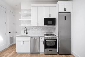 Brooklyn apartment for rent - A modern kitchen with white cabinets and stainless steel appliances.