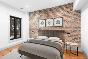 Brooklyn apartment for rent - A bedroom with a brick wall and a bed.