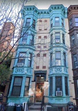 Brooklyn apartment for rent - A brown building with a blue building in front of it.