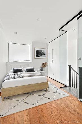 Brooklyn apartment for rent - A bedroom with a bed, a rug, and a painting on the wall.