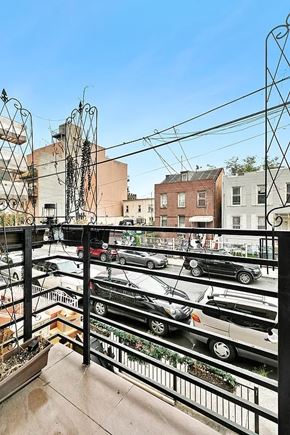 Brooklyn apartment for rent - A balcony with a view of a parking lot and buildings.