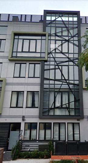 Brooklyn apartment for rent - A modern building with a large window and a black metal structure on the side.