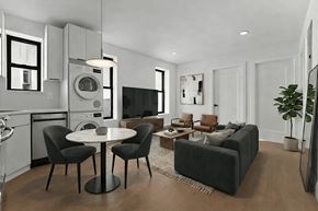 Brooklyn apartment for rent - A modern living room with a black sofa, a white table, and a television.