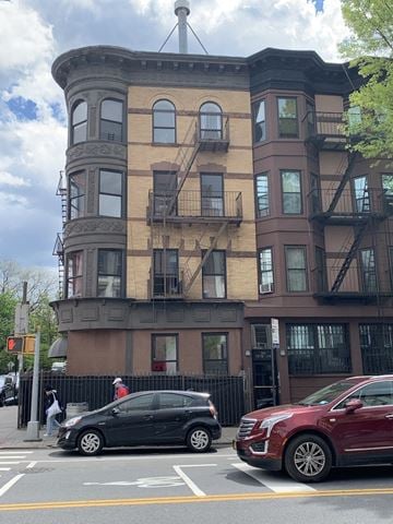 Brooklyn apartment for rent - A black car is parked on the side of the road in front of a red car.