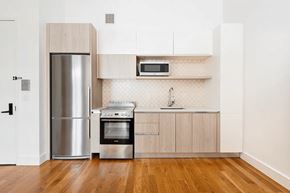 Brooklyn apartment for rent - A kitchen with a stainless steel refrigerator, oven, and microwave.