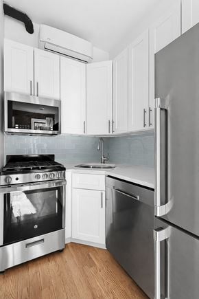 Brooklyn apartment for rent - A modern kitchen with stainless steel appliances and white cabinets.