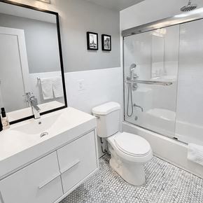 Brooklyn apartment for rent - A white toilet sits in a bathroom next to a sink and a shower.