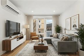 Brooklyn apartment for rent - A modern living room with a grey couch, a wooden coffee table, and a flat screen TV mounted on the wall.