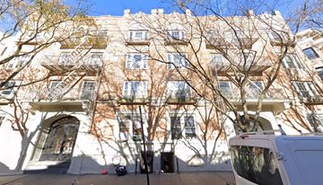 Brooklyn apartment for rent - A white van is parked on a street in front of a building with a tree in front of it.