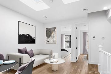 Brooklyn apartment for rent - A living room with a white couch and a painting on the wall.