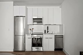 Brooklyn apartment for rent - A modern kitchen with white appliances and cabinets.